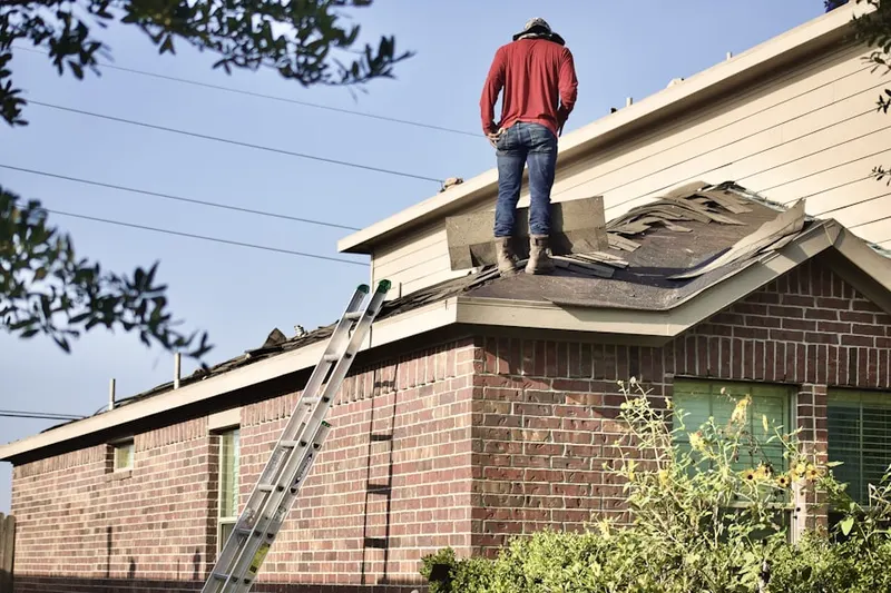 Professional roofer working on a residential roof in New England Village